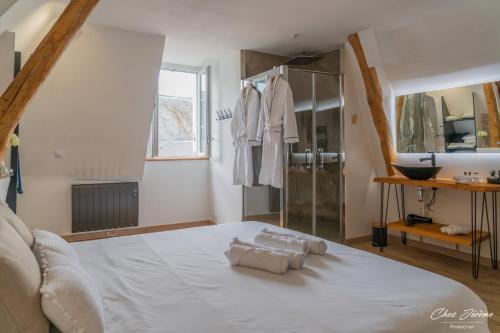 een slaapkamer met een groot wit bed en een badkamer bij Amboise et Volupté centre-ville in Amboise