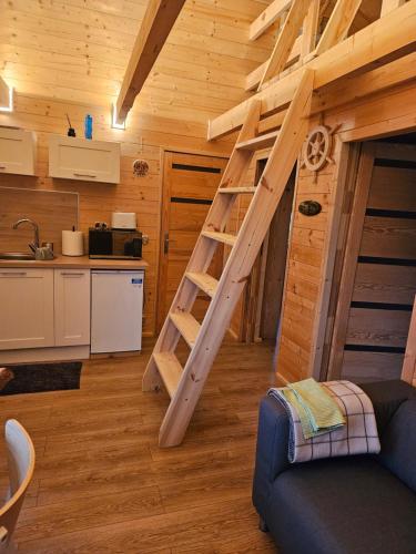 a loft bed in a room with a kitchen at Mazurski Sen in Wyszowate