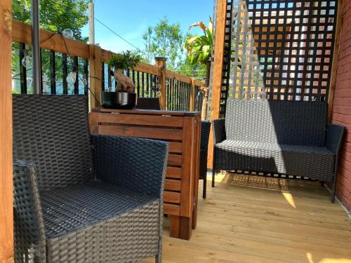 a porch with two chairs and a table with a cat on it at Appartement au coeur de Villeray in Montréal
