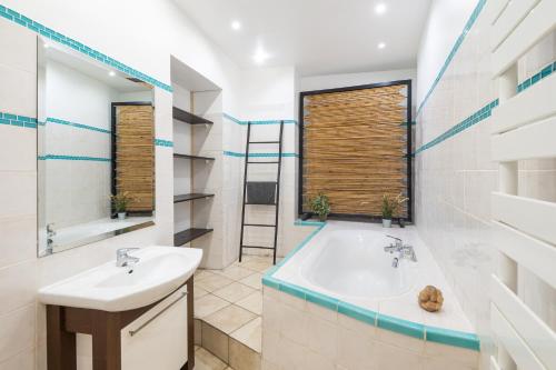 a bathroom with a tub and a sink and a mirror at "Le Zen" by EnjoyNice, central spacious apartment with Airco, beach at 10 min in Nice