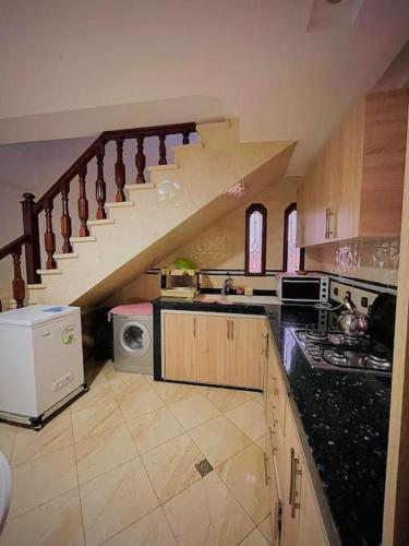 a kitchen with a staircase and a stove and a microwave at Petite villa palmeraie d Aglou in Tiznit