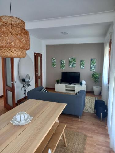 a living room with a blue couch and a table at Buddies Charm Apt - Self Catering in Aveiro