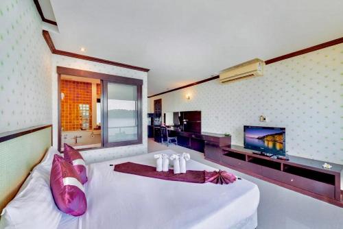 a bedroom with a large white bed and a television at Racha Kiri Resort & Spa, Khanom in Khanom