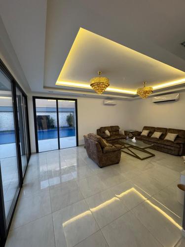 a large living room with couches and windows at شاليه مسك الريم Misk R chalet in Al Rama