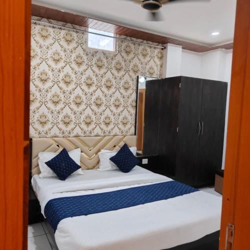 a bedroom with a large bed with blue pillows at RK Hotel & Restaurant in Dewās