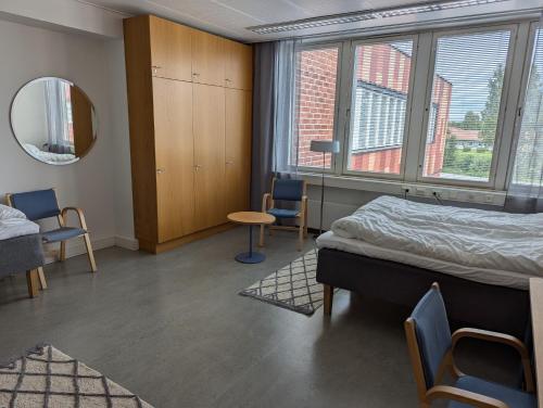 una camera ospedaliera con un letto e un tavolo con sedie di CityLoginn a Närpiö