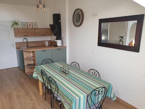 - une salle à manger avec une table, des chaises et un miroir dans l'établissement Au calme avec terrasse, clim et parking clos, à Montévrain