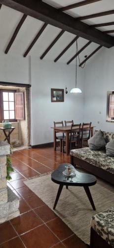 ein Wohnzimmer mit Sofa und Tisch in der Unterkunft Casa Grande - Casas de Campo na Serra da Estrela in Paços da Serra