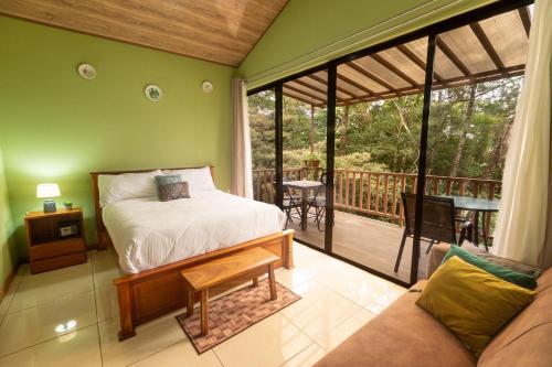 a bedroom with a bed and a balcony at Casas Clusia in Monteverde Costa Rica