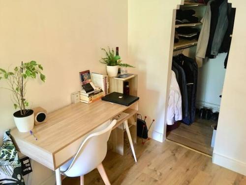 un bureau en bois dans une pièce avec un placard dans l'établissement Charmant Appartement Proche des Buttes-Chaumont, à Paris