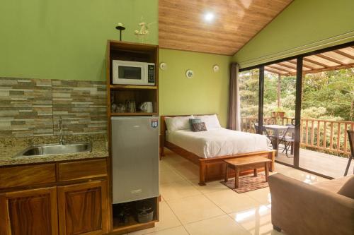 a bedroom with a bed and a kitchen with a microwave at Casas Clusia in Monteverde Costa Rica