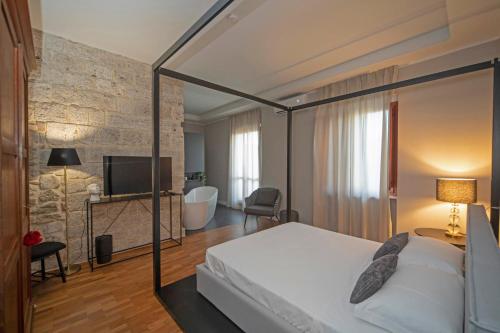 a bedroom with a bed and a tv in a room at Nella Torre Bed & Breakfast in Ascoli Piceno