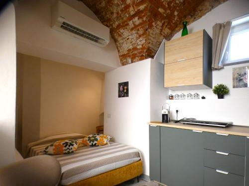 a small room with a bed and a kitchen at Il Piccolo Convento- NUOVA GESTIONE 2025- in La Spezia