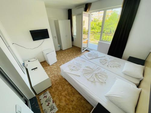 a small bedroom with two beds and a balcony at Apartments Lozenets in Lozenets