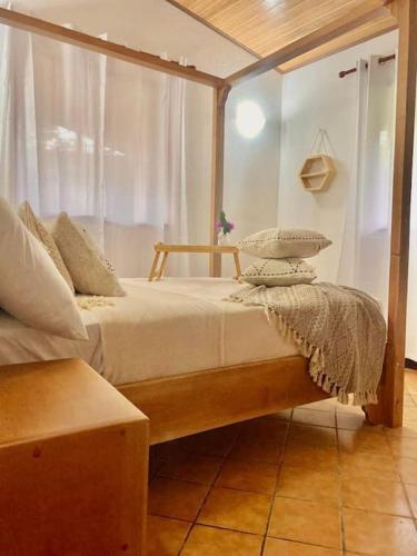 a bedroom with a bed with a wooden frame at Tu Casa en la Playa in Cahuita