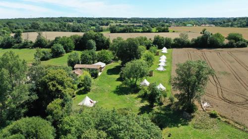 - une vue aérienne sur une ferme avec des tentes dans un champ dans l'établissement L'écolodge des champs, à Prailles