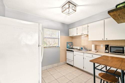 a kitchen with white cabinets and a table at Boutique Beach Retreat in St Pete Beach