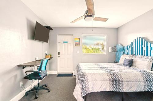 a bedroom with a bed and a desk and a ceiling fan at Boutique Beach Retreat in St Pete Beach