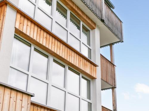 a building with white windows and a wooden facade at Apart33 Top 1-22 in Haus im Ennstal