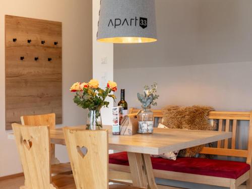 a dining room with a wooden table with flowers on it at Apart33 Top 1-22 in Haus im Ennstal
