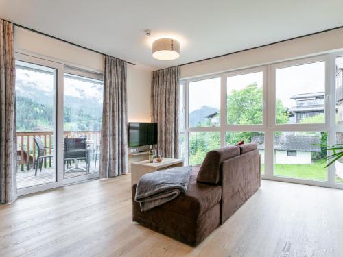a living room with a couch and large windows at Apart33 Top 1-22 in Haus im Ennstal