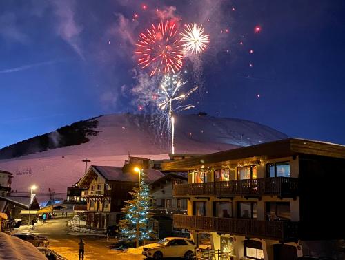 a fireworks display in front of a snow covered mountain at Homency - Chalet Jepima II in L'Alpe-d'Huez