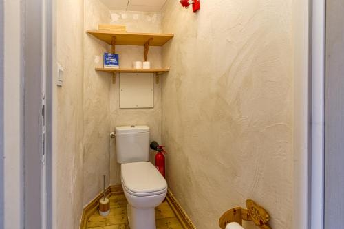a small bathroom with a toilet in a room at Homency - Chalet Jepima II in L'Alpe-d'Huez