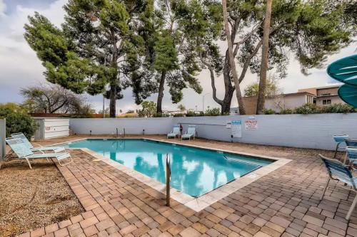 a swimming pool with chairs and a fence and trees at Luxury Condo in Old Town Scottsdale wPool in Scottsdale