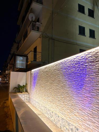 a brick wall with purple lights next to a building at IG - "Villa Don Antonio" Apartments in Giardini Naxos