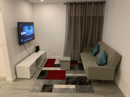 un soggiorno con divano e TV a schermo piatto di Spacious Bedroom In a Modern T3 Apartment a Costa da Caparica