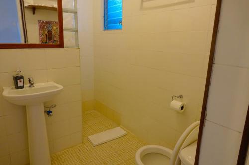 a small bathroom with a toilet and a sink at Casa Congo & Casa Rayo Verde - Restaurante - Galeria de arte in Portobelo