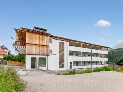 a white building with a wooden roof at Apart33 Top 2-3B in Haus im Ennstal