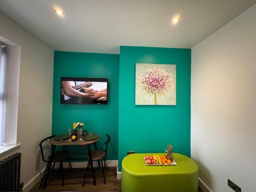 a room with a green ottoman and a table with a flower on it at Southgate Luxury Apartments-Jaquzzi Bath-Private Parking- 2 Min M62 in Elland