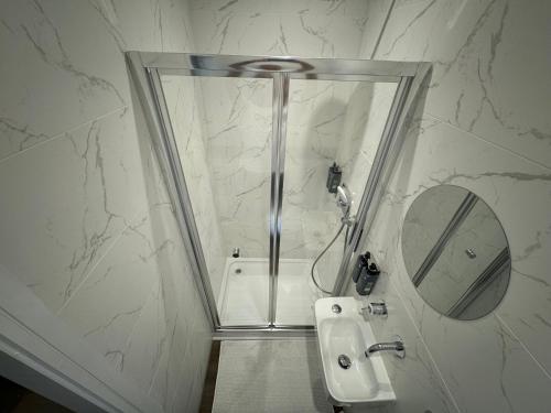 a white bathroom with a sink and a mirror at Southgate Luxury Apartments-Jaquzzi Bath-Private Parking- 2 Min M62 in Elland