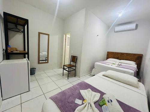 a room with two beds and a mirror at Mansomar in Jericoacoara