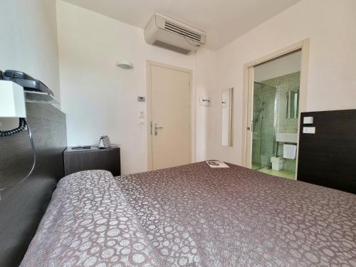 a bedroom with a bed and a bathroom at Hotel Morena in Lido di Jesolo