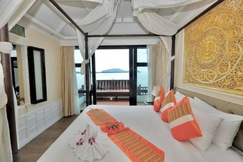 a bedroom with a large white bed with orange pillows at Racha Kiri Resort & Spa, Khanom in Khanom