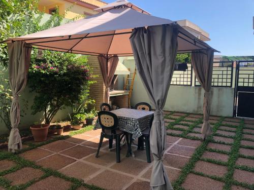 an umbrella over a table on a patio at Casa vacanze a due passi dal Poetto in Maracalagonis