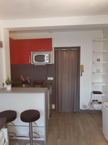 une cuisine avec un comptoir et des tabourets dans une pièce dans l'établissement Studio, à Bayonne