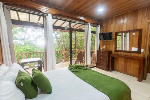 a bedroom with a large bed and a balcony at Casas Clusia in Monteverde Costa Rica
