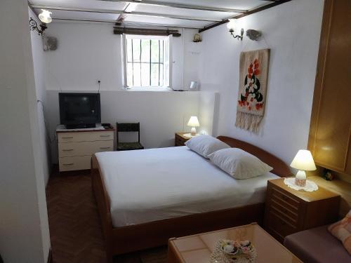 a small bedroom with a bed and a television at Art House Old Village in Jesenice
