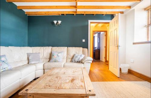 a living room with a white couch and a wooden coffee table at Bogma Cottages in Durham