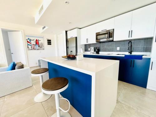 a kitchen with blue and white cabinets and stools at Paradise Retreat Peace Relaxation in Santa Bárbara de Samaná