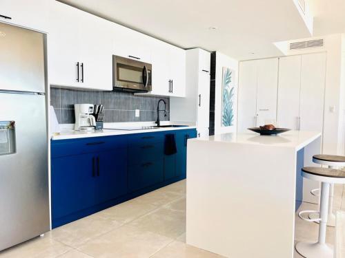 a kitchen with blue and white cabinets and a tv at Paradise Retreat Peace Relaxation in Santa Bárbara de Samaná
