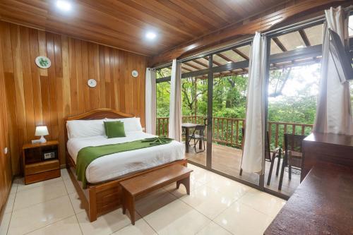 a bedroom with a bed and a balcony at Casas Clusia in Monteverde Costa Rica