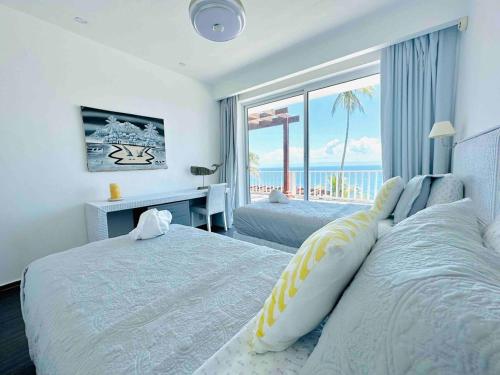 a bedroom with a bed with a view of the ocean at Saman - Paradise With A View - Vista Mare in Santa Bárbara de Samaná