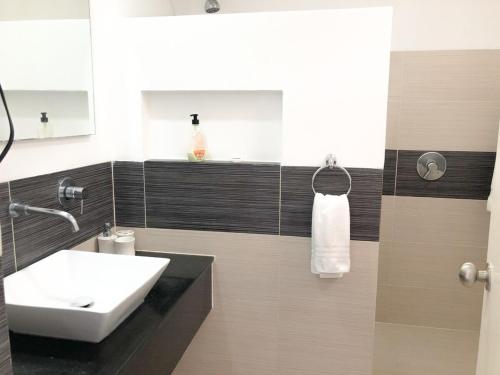 a bathroom with a sink and a toilet and a mirror at Saman - Paradise With A View - Vista Mare in Santa Bárbara de Samaná