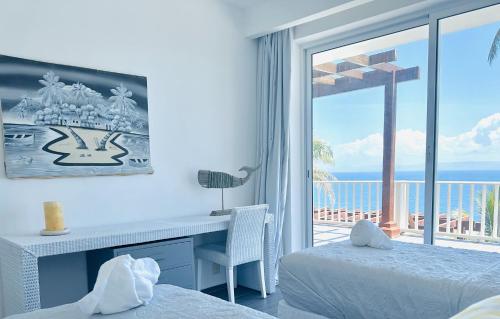 a bedroom with a desk and a view of the ocean at Saman - Paradise With A View - Vista Mare in Santa Bárbara de Samaná