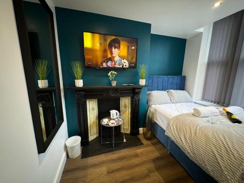 a bedroom with a bed and a tv on a wall at Southgate Luxury Apartments-Jaquzzi Bath-Private Parking- 2 Min M62 in Elland