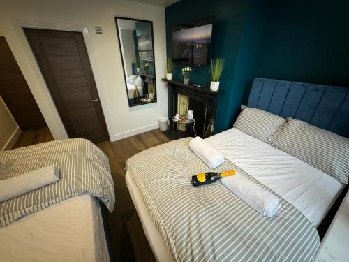 a bedroom with two beds with a tool on it at Southgate Luxury Apartments-Jaquzzi Bath-Private Parking- 2 Min M62 in Elland